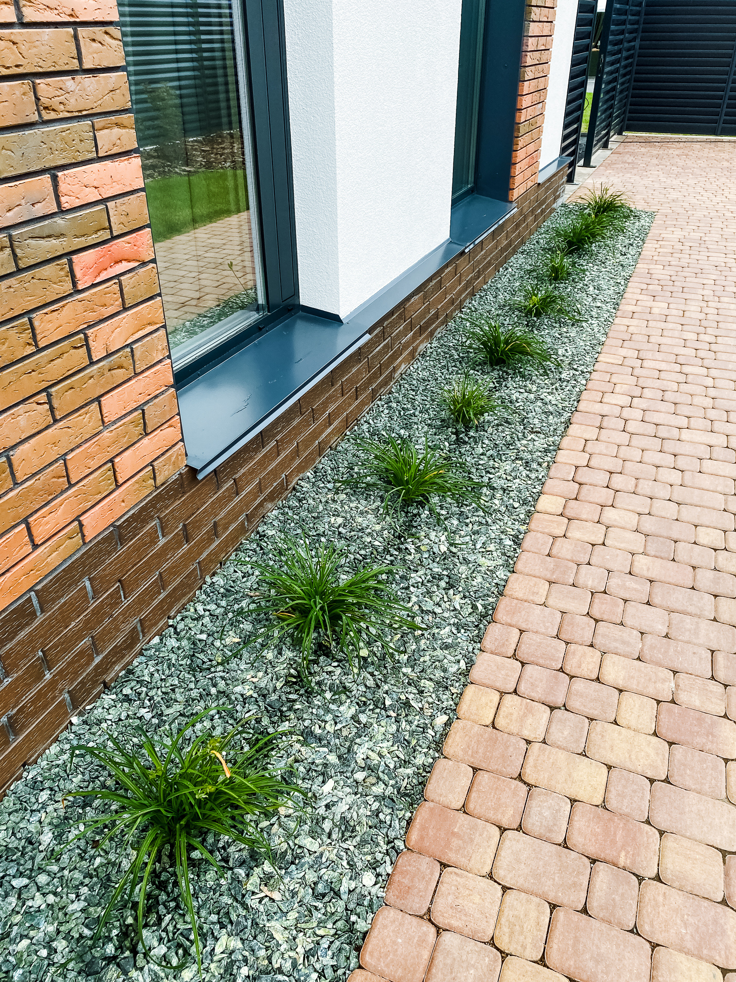 Contemporary Landscaping Design blends Decorative Stones with lush Green Grass, enhancing Modern Houses and creating inviting outdoor spaces that connect with nature and provide tranquility